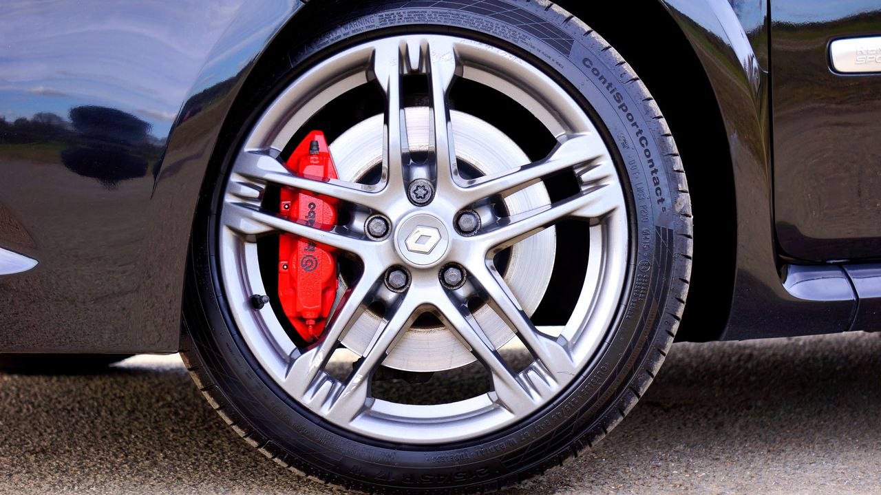 who-we-are Detailed view of a Renault car wheel with a red brake caliper on display.