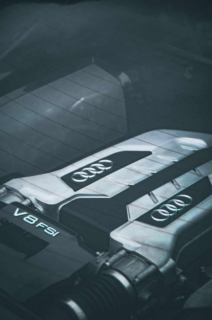 Detailed view of an Audi V8 engine showing the logo and parts in focus.
