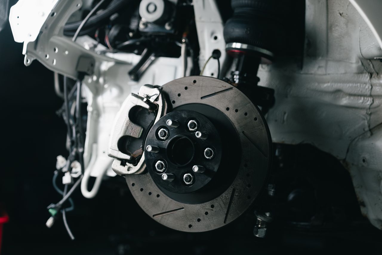 Detailed view of a vehicle's disc brake system with caliper, showcasing automotive technology.