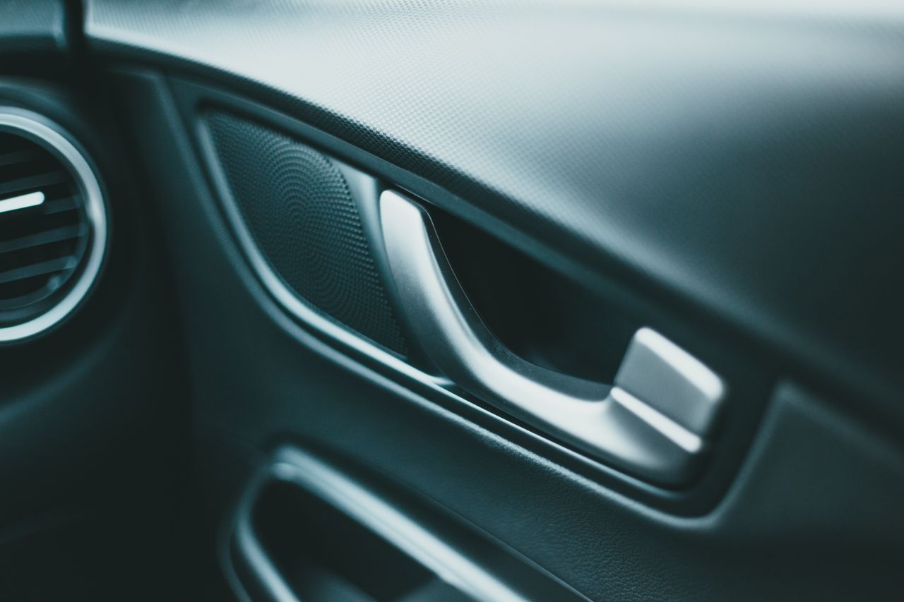 Closeup of closed door and speaker near shiny door handle of modern car in daylight